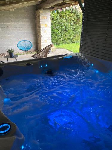 une baignoire remplie d'eau bleue à côté d'une chaise dans l'établissement Cottage L’O RIO, à Anais