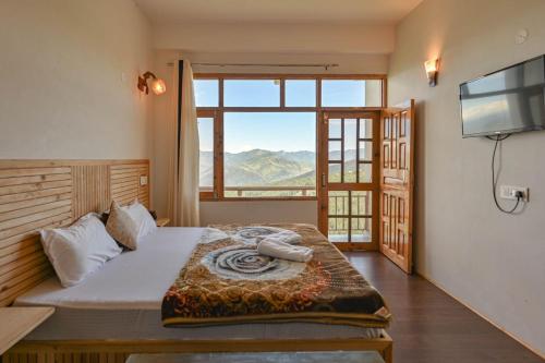 a bedroom with a bed and a large window at Kaith Cottage in Kūfrī