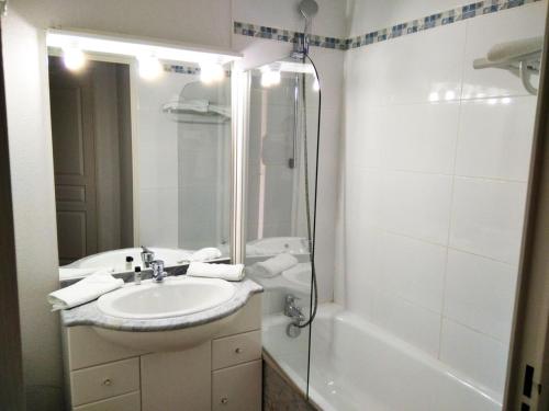 uma casa de banho branca com um lavatório e um chuveiro em Résidence Pic Du Midi - 2 Pièces pour 4 Personnes 694 em La Mongie