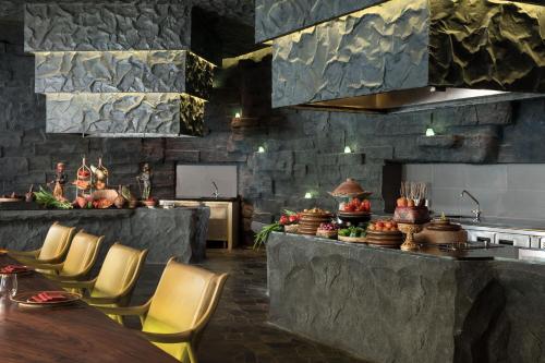 a kitchen with a counter with chairs and a table at The Ritz-Carlton Bali in Nusa Dua