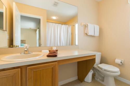 a bathroom with a sink and a toilet and a mirror at Kosies Lake Escape in Orlando