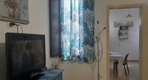 a living room with a television and a curtain at A 2 passi da tutto in Trapani