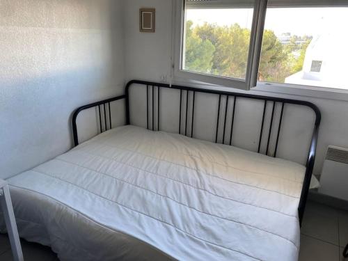 - un lit avec une couverture blanche dans l'établissement Studio fonctionnel quartier faculté St Jérôme, à Marseille