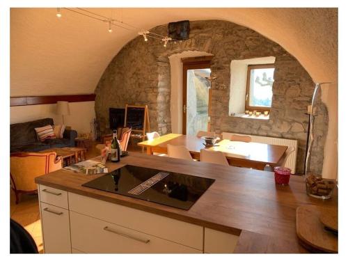 a kitchen with a counter and a stone wall at La Vigneronne, Garden in Blonay
