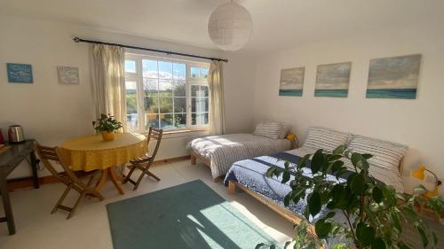 a living room with a bed and a table and a window at Happy Hill in Youghal