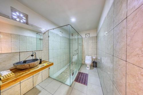 a bathroom with a sink and a shower and a toilet at Puri Garden Penida in Nusa Penida