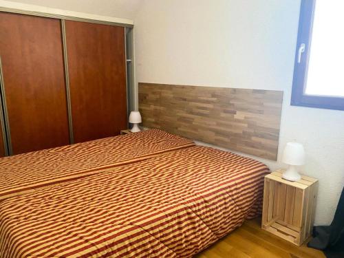 1 dormitorio con cama y cabecero de madera en Résidence Pic Du Midi - 3 Pièces pour 7 Personnes 124, en La Mongie