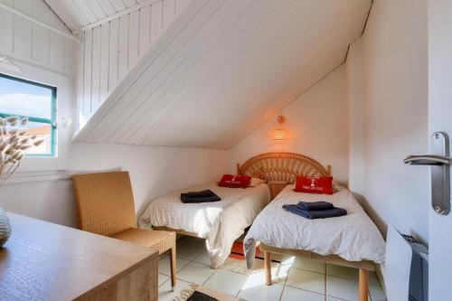 une chambre mansardée avec deux lits et une table dans l'établissement Résidence Port Bourgenay - maeva Home - Appartement 4 pièces 6 personnes - Exclusive - super Home MAE-8814, à Talmont-Saint-Hilaire