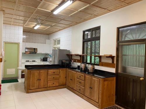a large kitchen with wooden cabinets and black counter tops at Taoyuan Villa B&B in Puli