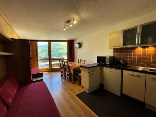 une cuisine et une salle à manger avec une table et des chaises dans l'établissement Résidence Grande Masse - Appartement pour 5 en bord de piste aux Ménuires MAE-4894, aux Menuires