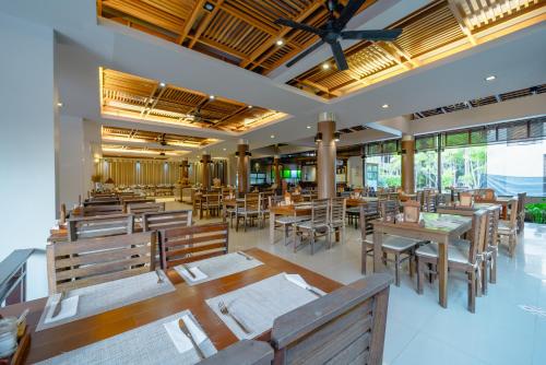 a restaurant with wooden tables and chairs and windows at Railay Princess Resort & Spa in Railay Beach