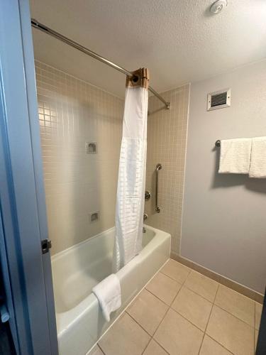 a bathroom with a tub and a shower curtain at Super 8 by Wyndham Dallas Love Field Airport in Dallas