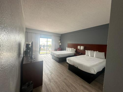 a hotel room with two beds and a window at Super 8 by Wyndham Dallas Love Field Airport in Dallas