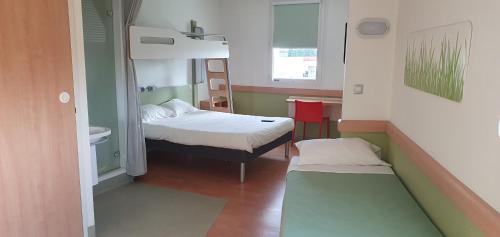 a small room with a bed and a sink at Ibis Budget Roanne Hôtel in Roanne
