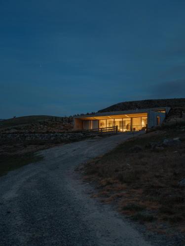 a house on the side of a hill at night at Bunker House in Lake Tekapo