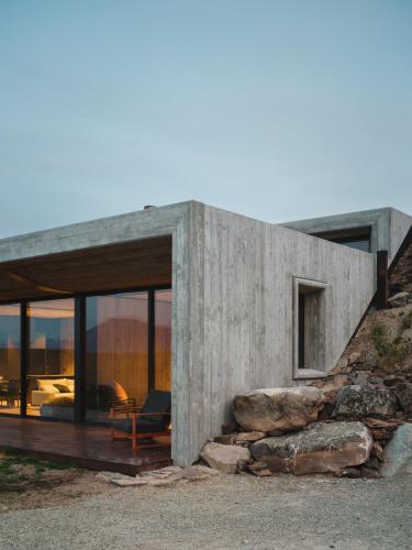 een betonnen huis op een heuvel met glazen deuren bij Bunker House in Lake Tekapo