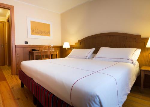 a large white bed in a hotel room at Cresta Et Duc Hotel in Courmayeur