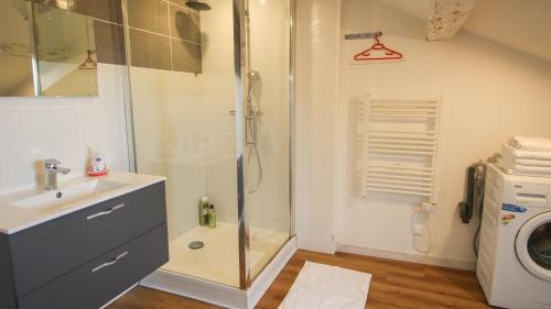 a bathroom with a shower and a sink and a washing machine at Residence Pasteur Angouleme in Angoulême