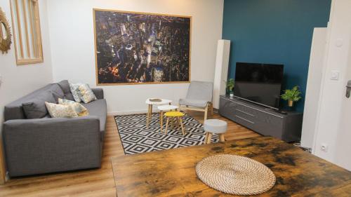 a living room with a couch and a tv at Residence Pasteur Angouleme in Angoulême