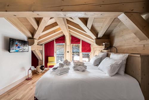 a large white bed in a room with wooden ceilings at Résidence Saint Joseph - Chalets pour 11 Personnes 294 in Val-d'Isère