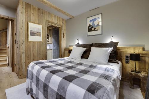 1 dormitorio con cama a cuadros en blanco y negro en Résidence RÉsidence Kilimanjaro - 3 Pièces pour 5 Personnes 814, en Val dʼIsère