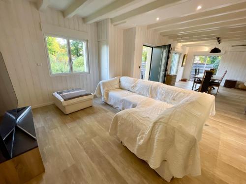 un salon avec un canapé blanc et une table dans l'établissement Ferienhaus mit beheiztem Pool in Claouey, à Lège-Cap-Ferret