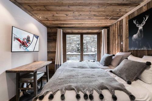 a bedroom with a large bed and a wooden ceiling at Residence La Canadienne - 5 Pièces pour 8 Personnes 624 in Val dʼIsère