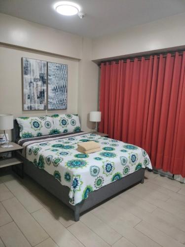 een slaapkamer met een bed en rode gordijnen bij Condotel Near Airport Pasay City in Manilla