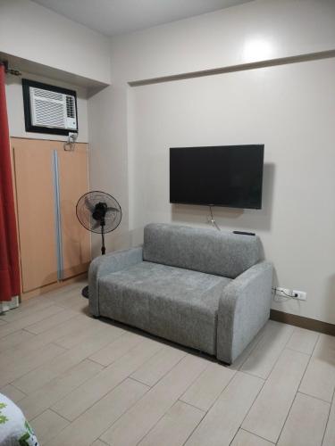 een woonkamer met een bank en een flatscreen-tv bij Condotel Near Airport Pasay City in Manilla
