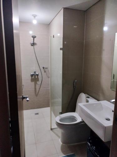een badkamer met een douche, een toilet en een wastafel bij Condotel Near Airport Pasay City in Manilla