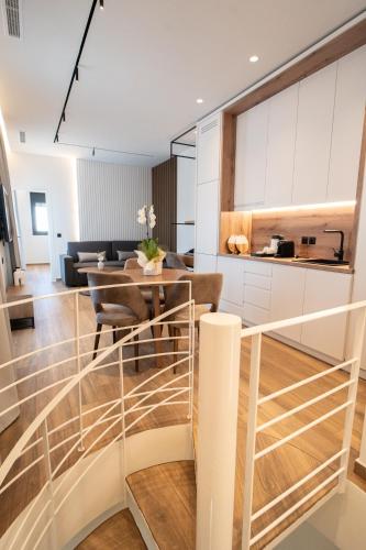 a kitchen and living room with a staircase and a table at Volos Inn Hotel in Volos