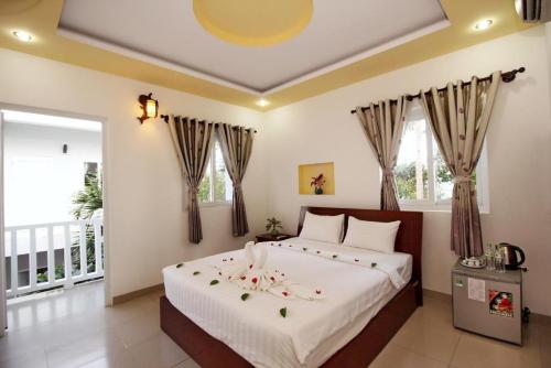 una camera da letto con un grande letto con fiori di NỤ CƯỜI MŨI NÉ HOTEL a Ấp Thiện Long
