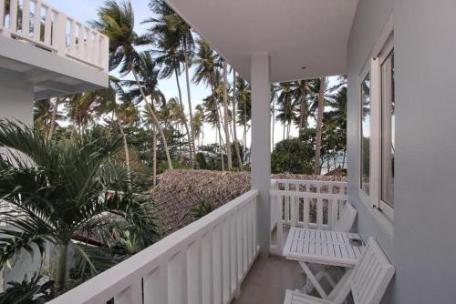 balcone con ringhiera bianca e palme di NỤ CƯỜI MŨI NÉ HOTEL a Ấp Thiện Long