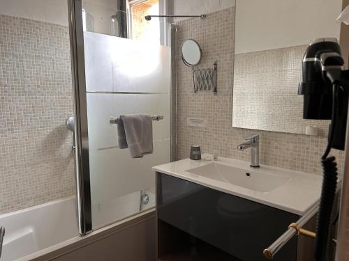 La salle de bains est pourvue d'un lavabo et d'une douche. dans l'établissement Logis La Bastide des Golfs, à Mouans-Sartoux