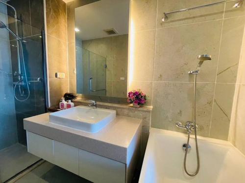a bathroom with a sink and a shower at The Astra Bozz Room in Chiang Mai