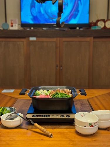 a pan of food sitting on top of a table at 源泉掛け流し付き貸切別荘-Authentic private home with Private Kusatsu Onsen - THE HIDEOUT VILLA KUSATSU- in Kusatsu
