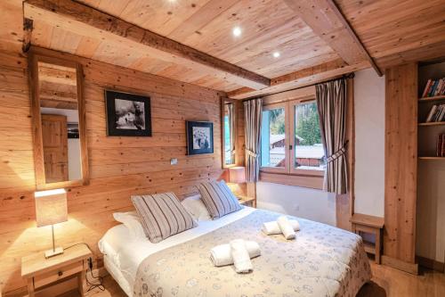 una camera con un letto in una stanza con pareti in legno di Résidence Hameau De La Blaitiere - 3 Pièces pour 6 Personnes 674 a Chamonix-Mont-Blanc