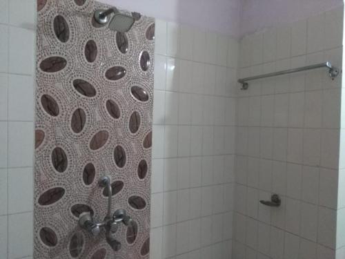 a bathroom with a shower with a stone wall at Rupmati The Valley Hotel in Māndu