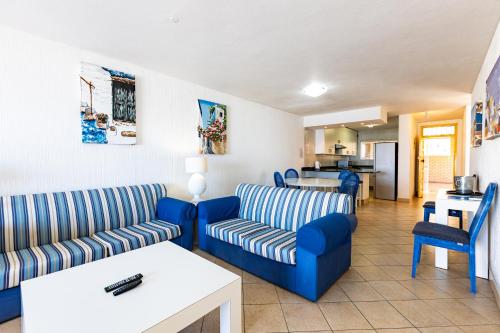 sala de estar con 2 sofás azules y cocina en Club 10 Unit 5, en Ballito