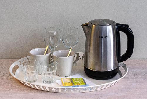 a tray with a coffee pot and glasses on it at Nykščio Namai & SPA in Anykščiai