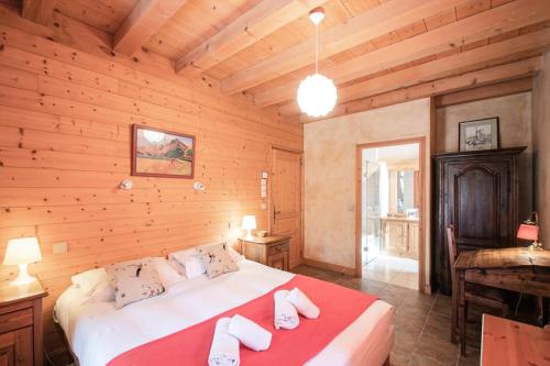 ein Schlafzimmer mit einem großen Bett in einem Holzzimmer in der Unterkunft Résidence Perseverance - Chalets pour 12 Personnes 054 in Chamonix-Mont-Blanc