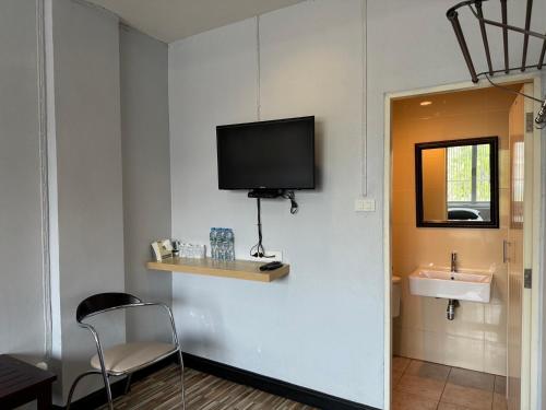 a room with a sink and a tv on a wall at norndee hostel in Aranyaprathet