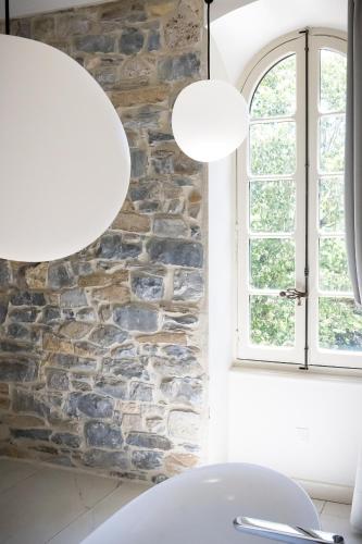 a room with two lights and a stone wall at Couvent de la Salette & Spa in Millau