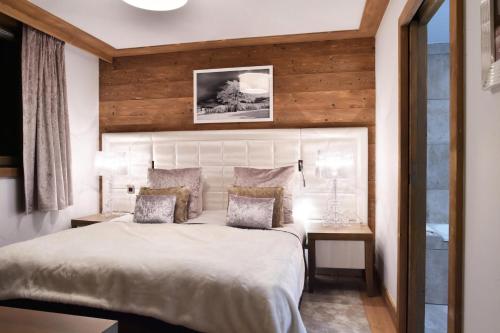 1 dormitorio con 1 cama grande y pared de madera en Résidence Carre Blanc - 2 Pièces pour 2 Personnes 084, en Courchevel
