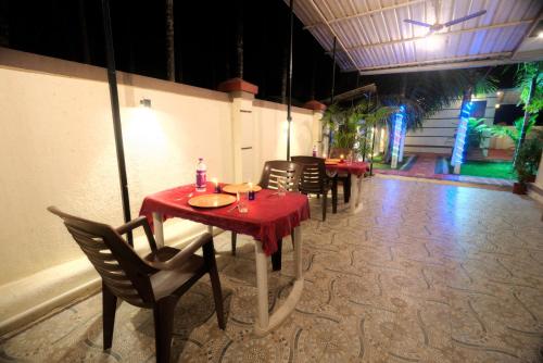 a restaurant with red tables and chairs in a room at Hotel Snehaprabha - Near to Nagaon Beach Alibaug in Alibaug