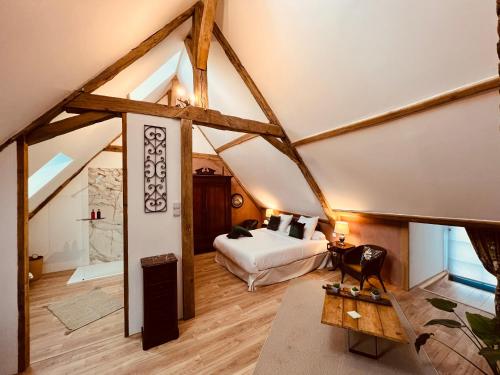 een slaapkamer met een bed op zolder bij Le Presbytere de Leyrat 