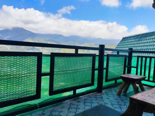 a balcony with a bench and a view of the mountains at Nulu View Cabin in Kundasang