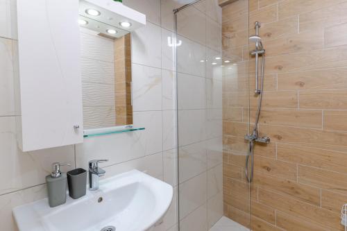 y baño con lavabo y ducha. en Mirela Guest Apartment en Veliko Tŭrnovo