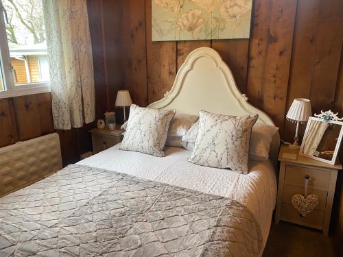 Schlafzimmer mit einem großen Bett und Holzwänden in der Unterkunft Chalet Thirty Two in Seaton