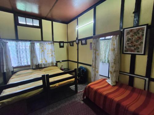 duas camas num quarto com duas janelas em Royal Pine em Shillong